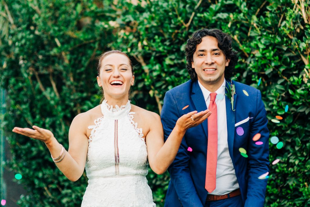 Bride and Grooms plays with colorful confetti