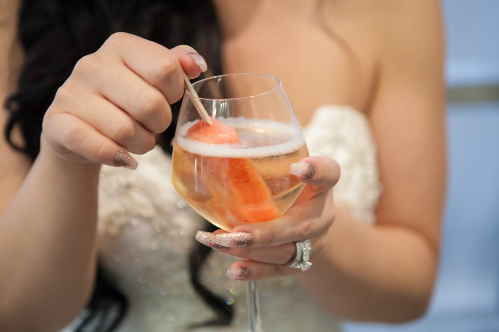 Bride on wedding day with champagne popsicle cocktail
