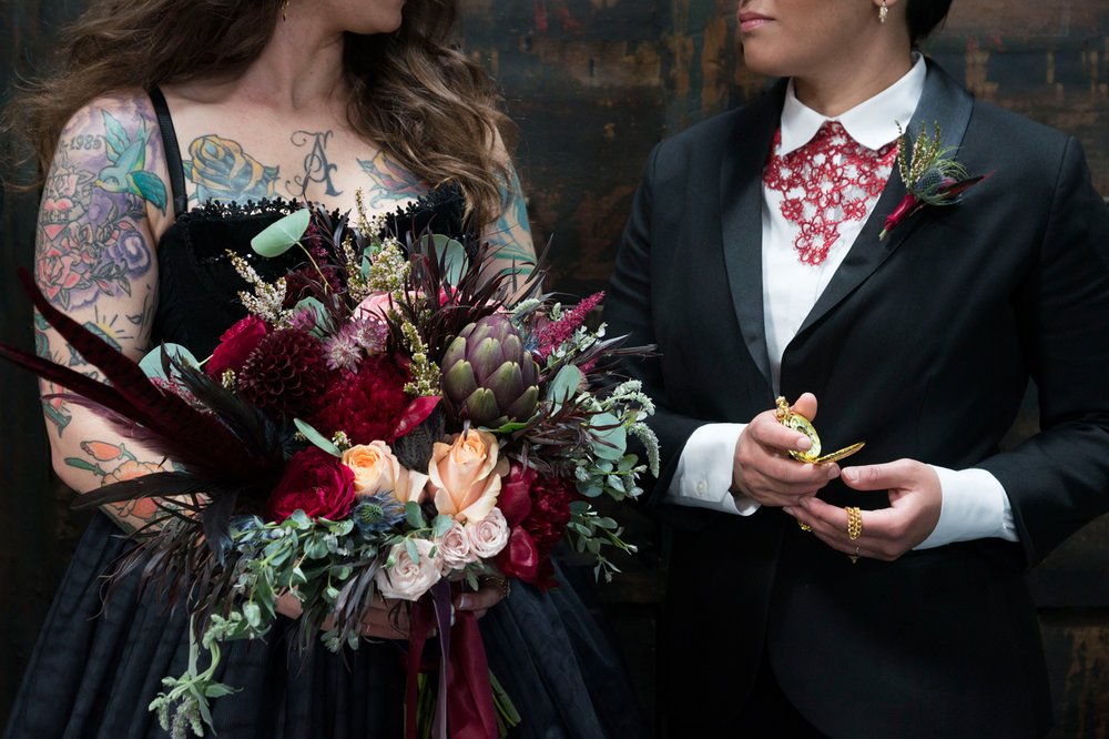 LBGTQ couple women tuxedo wedding dress black bridal bouquet