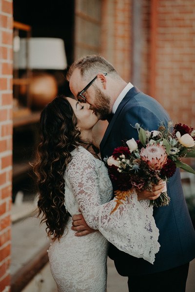Bride and groom kissing on boho chic wedding at at Big Daddy's Antiques 