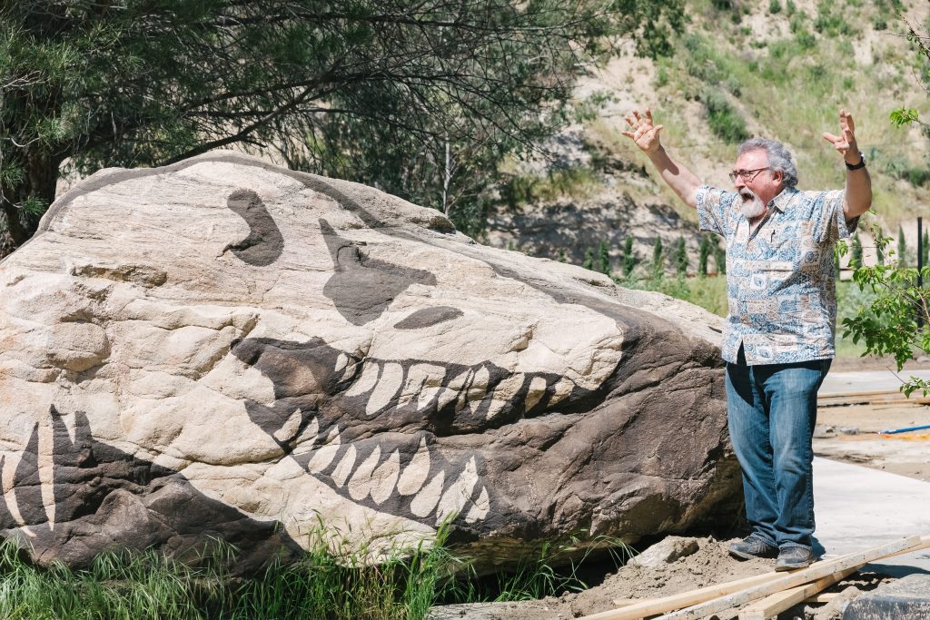 man screaming at dinosaur rock