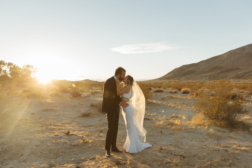 bride and groom kissing at sunet in joshua tree