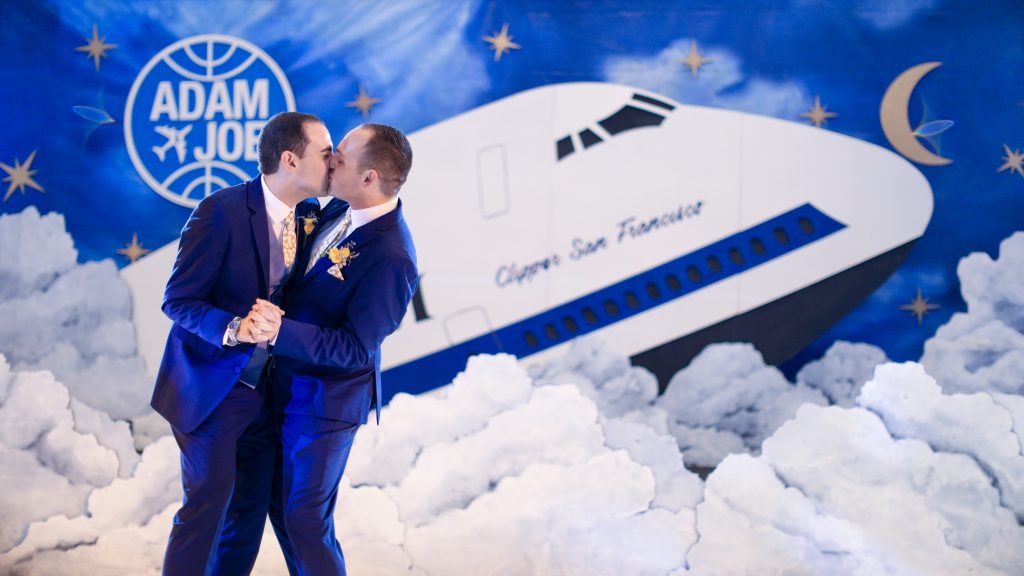 grooms kissing at airplane