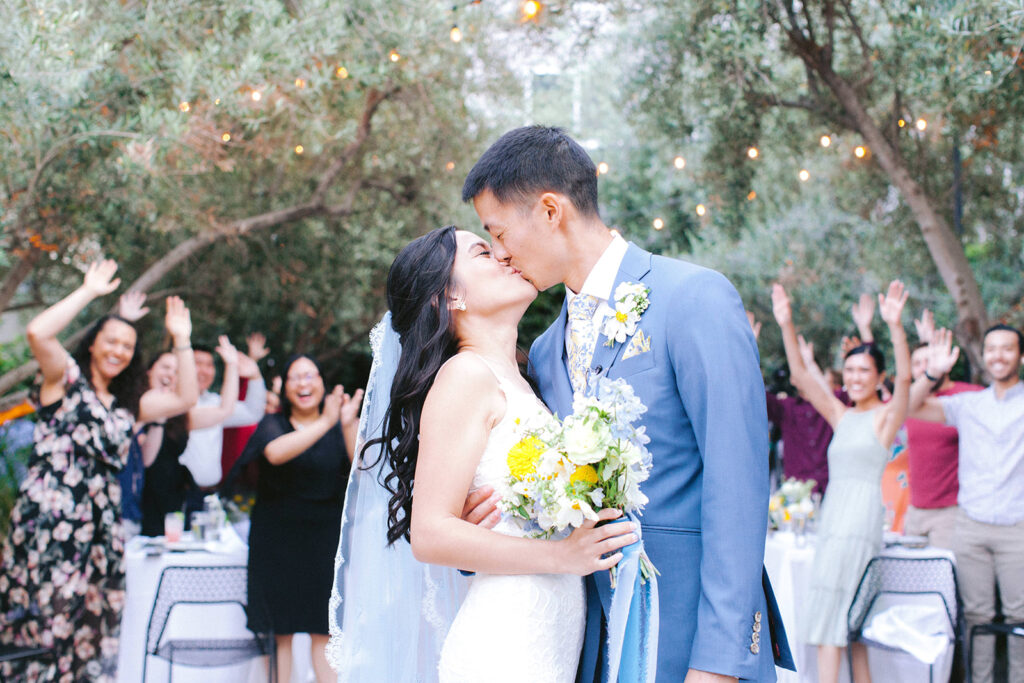 Bride and groom kiss at the end of the aisle after surprise wedding